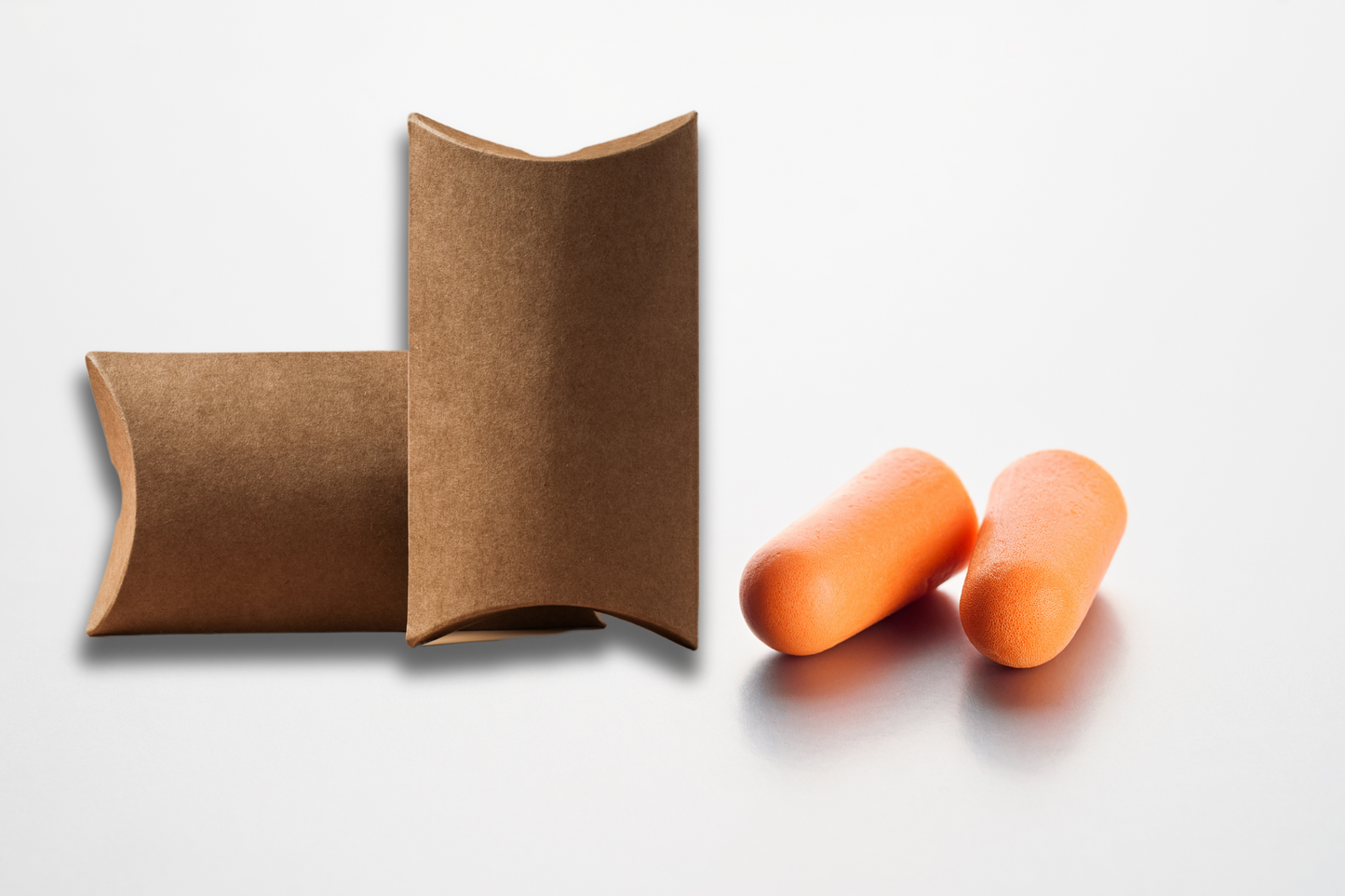 Fotografia štuple do uší v krabičke na vankúš s logom od JM Band®. Štuple do uší v oranžovej farbe si môžete kúpiť tu.